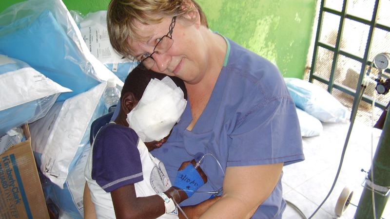 Agnes Hyma cuddles a young patient in Haiti.