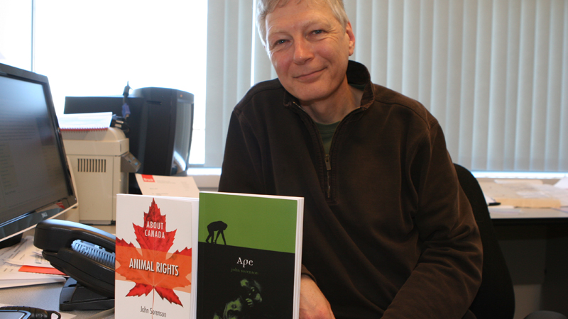 Professor John Sorenson poses with his two recent books, About Canada: Animal Rights and Ape.