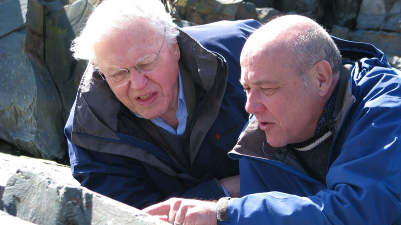 Guy Narbonne shows Sir David Attenborough evidence of the oldest, large, multicellular creature in the world at Mistaken Point during the filming of a BBC special.