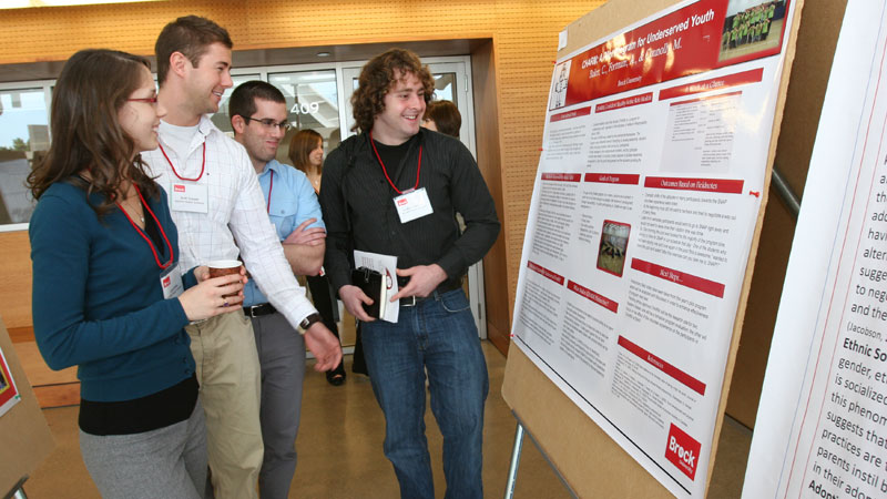 Examining a poster presentation are, from left, Applied Health Sciences graduate students Lara Green, Scott Crozier, Tyler Weaver and Andrew Fortnum.