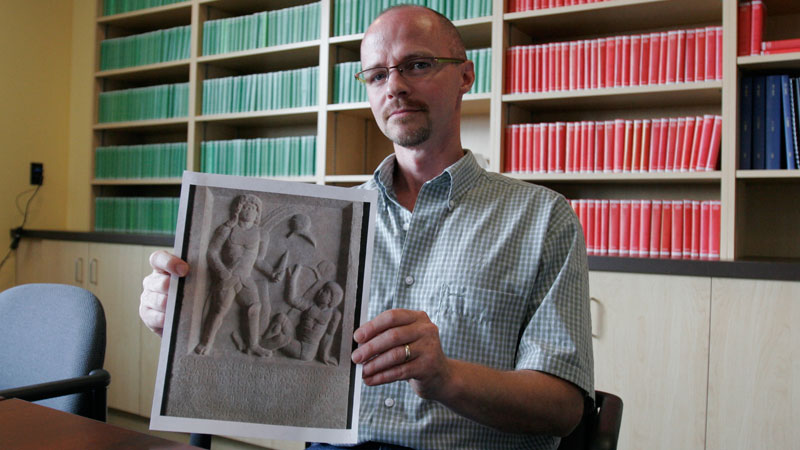 Michael Carter displays a photo of the gladiator tombstone he studied.