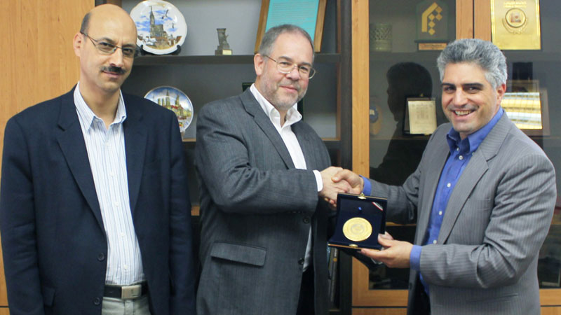 Martin Head, centre, is presented with a plaque bearing the emblem of the University of Tehran by Hasan Asadi, right, Vice-President International. Ebrahim Ghasemi-Nejad, right, is a professor in the university's Department of Geology.