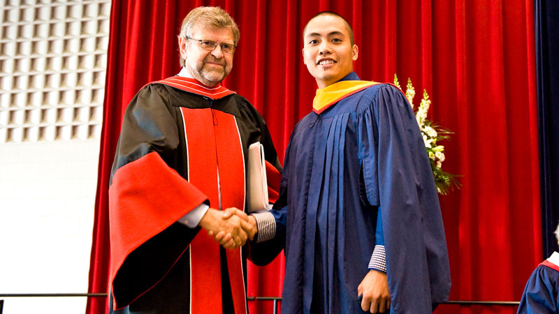 Val Andrei Fajardo, right, receives an award from Murray Knuttila, Provost and Vice-President Academic, at today's Convocation ceremony.