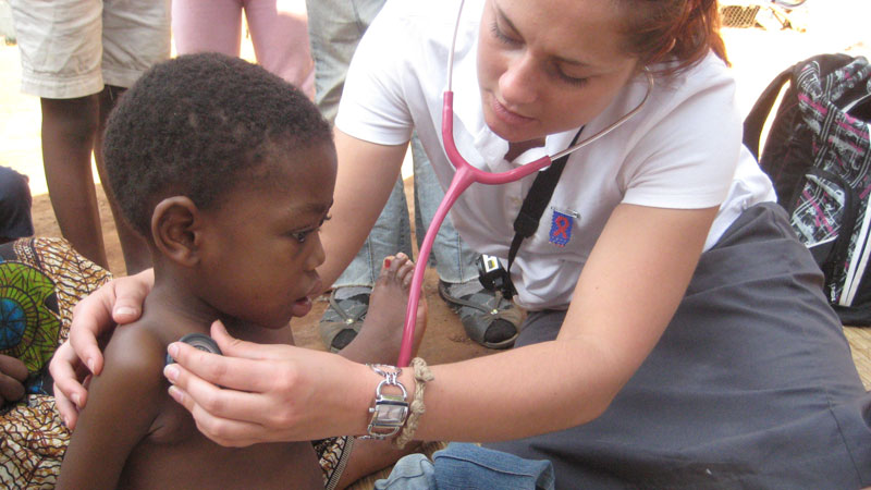 Student Ashley Toye examines a young patient in Swaziland.