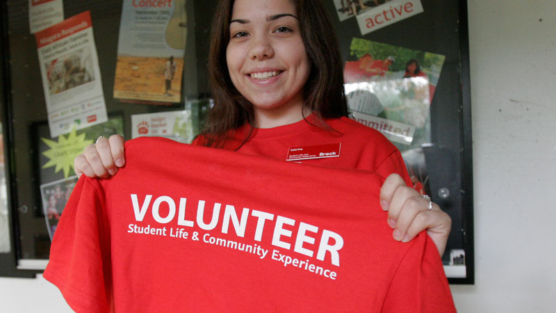 Sabrina Parrotta, student co-ordinator of Student and Community Outreach, shows off the T-shirt Brock students will be wearing for a day of community service this weekend.