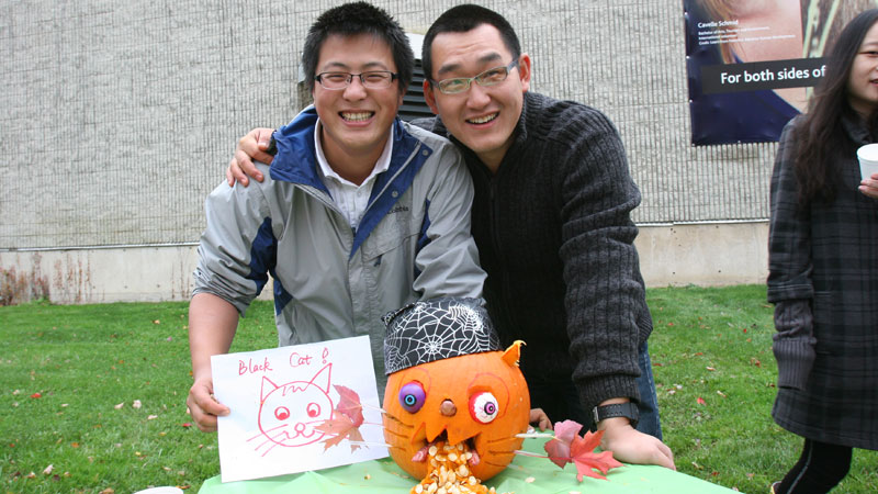 Master of Education (International Student Program) students Ziming Liu and Shaojie Yan pose with their pumpkin.