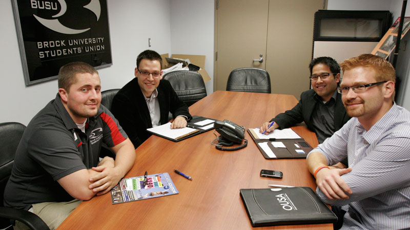 Meeting in a Brock University Students' Union boardroom are, from left, Luke Speers, BUSU's Vice-President University Affairs, OUSA executive director Sam Andrey, director of communications Alvin Tedjo, and president Sean Madden.