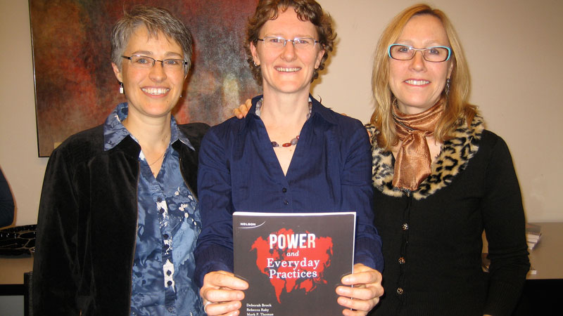 Sociology professors (from left) Mary Beth Raddon, Rebecca Raby and Margot Francis show off the newly published sociology textbook Power and Everyday Practices, during a recent book launch event.