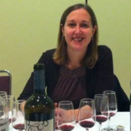 Emma Garner (BSc, ’04), Thirty Bench Winemaker, poses for a photo with her 2010 barrel sample of Meritage (a Bordeaux blend) after the Tutored Tasting