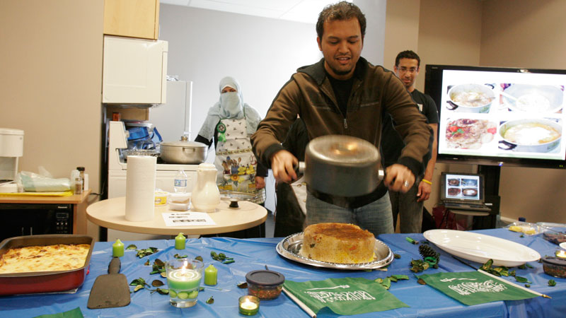 Student Ahmed Amin helps prepare a rice dish during a Saudi cooking demonstration.