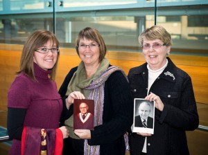 Three generations of Brock women: (left to right) Kate Dirks (MA ’12), Linda Dirks (BA ’84), Patricia Waters (BA ’88) with the graduation sash and photo of Lou Cahill (LLD ’91), and James Waters (BA ’77)