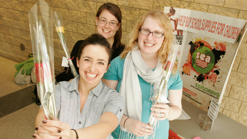 Natasha Davey, Katrien Ecclestone and Lisa Pollak, Concurrent Education students, sell flowers for Solidarity Experiences Abroad.