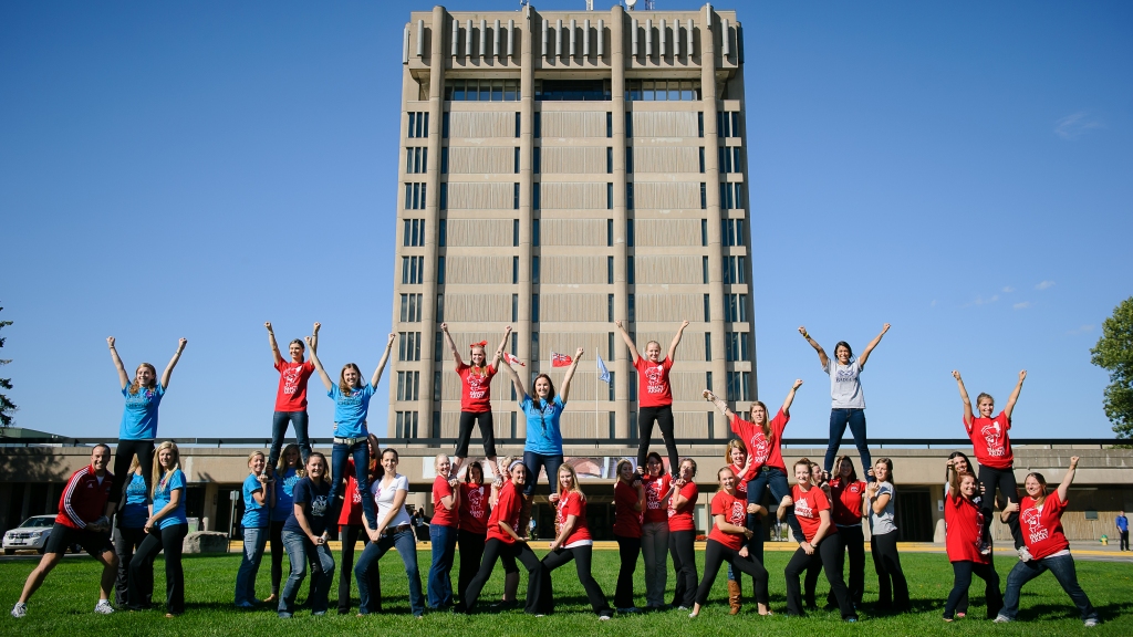 Brock cheerleaders posing in front of the Schmon Tower during their generational reunion.