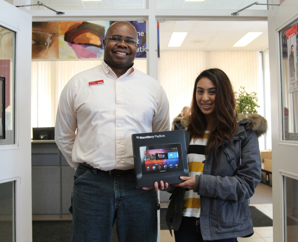 Amira Abdelhamid, a first-year neuroscience student, receives a new BlackBerry Playbook tablet from Troy Brooks, academic integrity officer. 