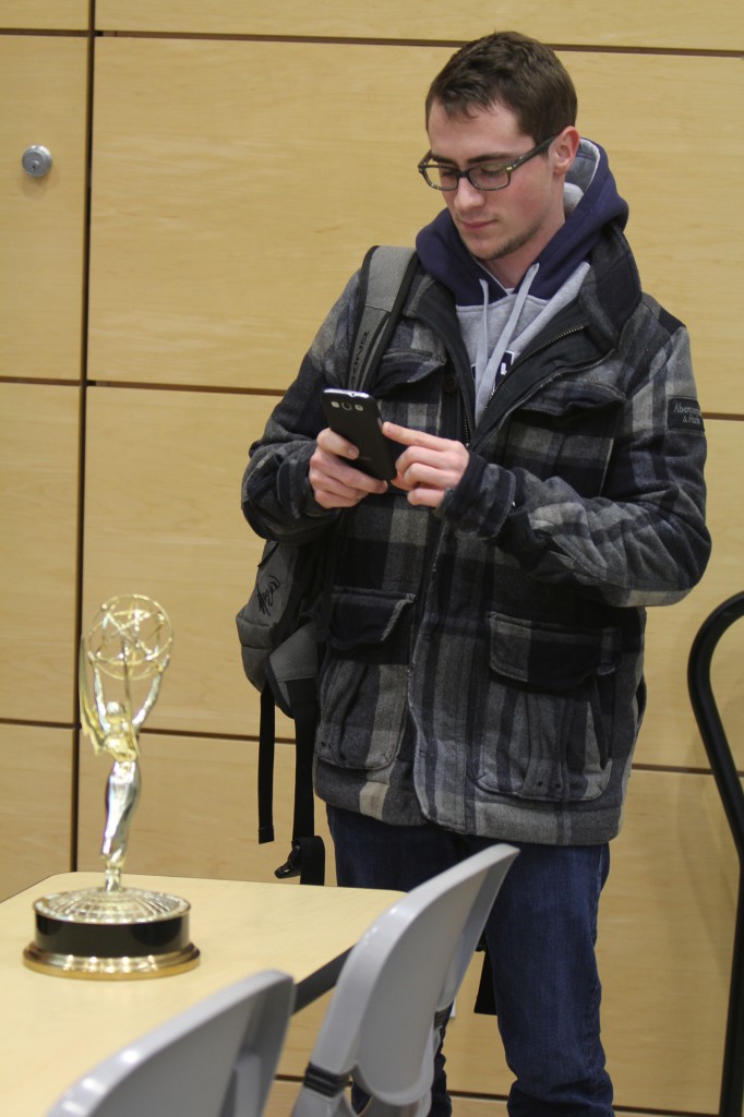 Josh Reid, a third-year sport managment student, snaps a picture of Ralph Mellanby's Emmy after the producer spoke to Reid's class Thursday.