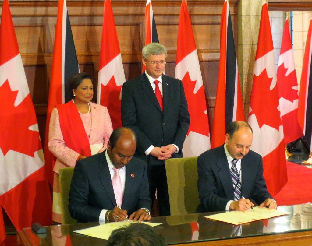 From left: Trinidadian Prime Minister Kamla Persad-Bissessar (standing); Curtis Manchoon, Chairman of the University of Trinidad and Tobago Board of Governors; Prime Minister of Canada Stephen Harper (standing); Brock University President Jack Lightstone (seated).