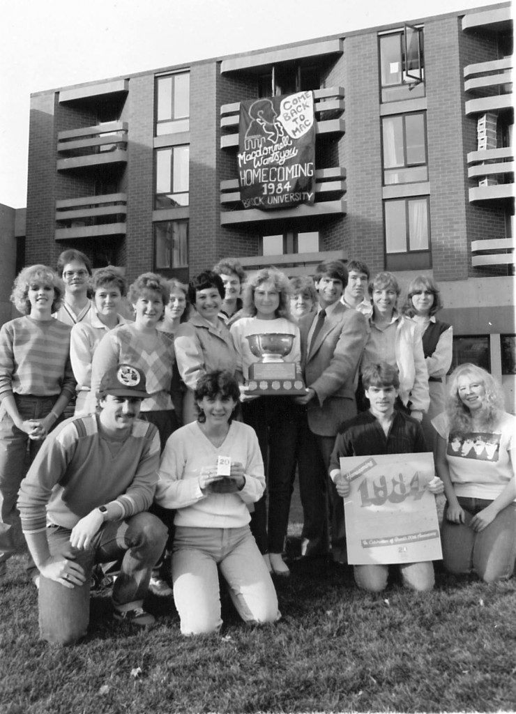 Jamie Fleming, then Director of Residence, with winners of the 1984 Homecoming banner contest award outside DeCew Residence
