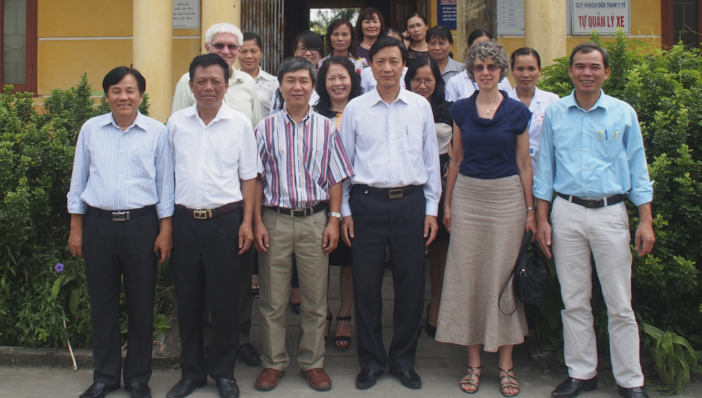 Nursing Prof. Lynn Rempel (second from right, front row) has received a grant for research in Vietnam about the importance of fathers in the development of their children's brains. She's seen here with  several of the research team members and the district health officials and some of the physicians who will be supporting our study in front of one of the commune health centres that will be an intervention site in the study. 