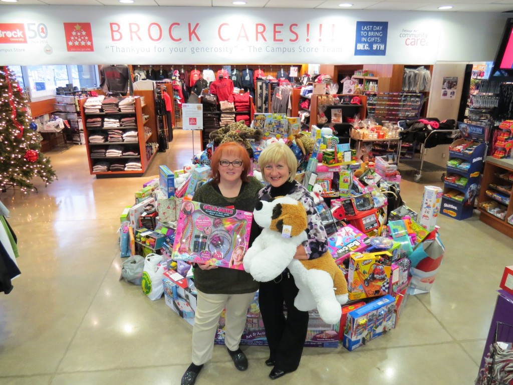 Tacey Atkinson, technology specialist at the Campus Store, and Nancy McIntosh from Community Care of St. Catharines and Thorold, show off the haul of toys brought in by Brock's annual Adopt an Angel campaign.