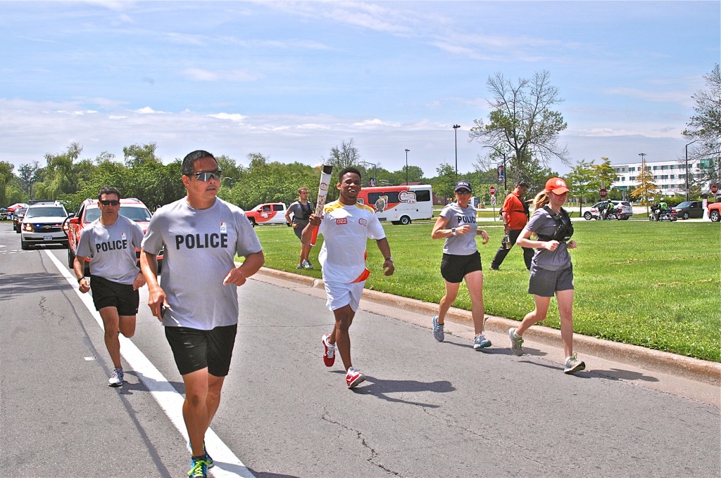 Police officers and Pan Am Games officials escorted torch-bearing Kyle Rose on to campus on Saturday.   