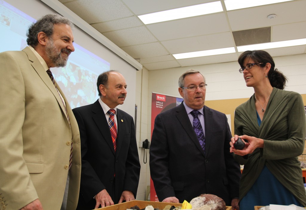 Mariek Schmidt (right) explains the significance of some of the rocks she is studying to (from left) Gary Libben, Vice-President, Researc, Brock President Jack Lightstone, and St. Catharines MPP Jim Bradley.