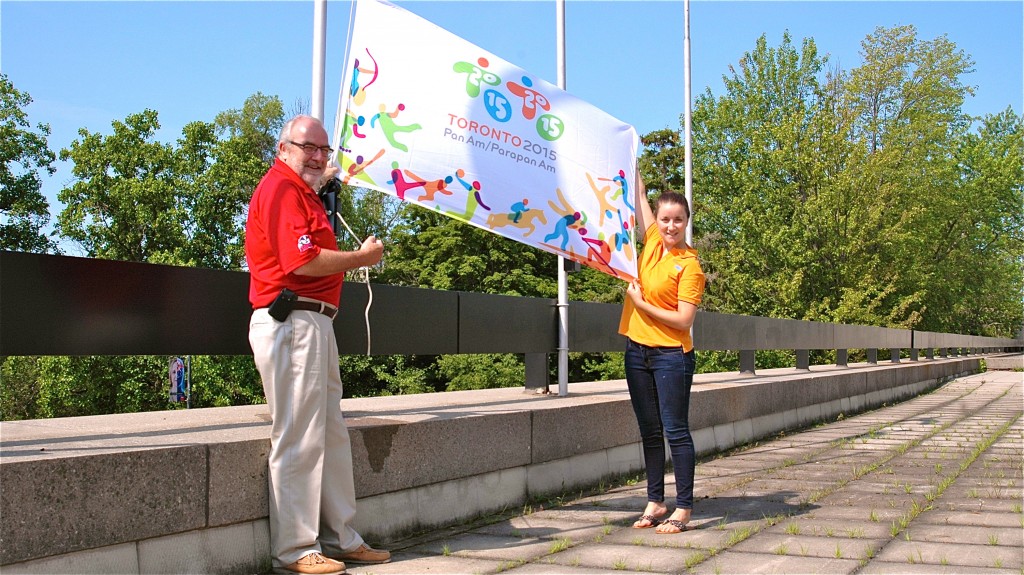 With flying colours: Colleen McGuire, a Brock alumna and site coordinator for the 2015 Pan Am Games, gets help raising the flag from Tom Arkell, Associate Vice President of University Services.