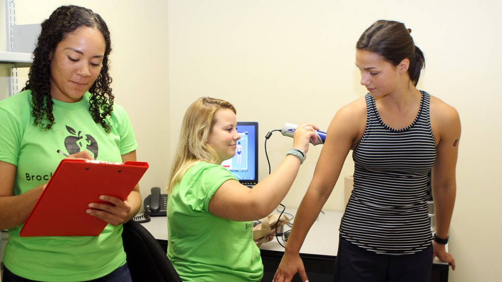 Brock University Kinesiology researchers Aysha Thomas, left, and Kayleigh Beaudry use body metric ultrasound equipment to test volunteer Amanda McKinnon. Participants in the Brock Transition Study will undergo similar testing to measure how the first year of university affects them.