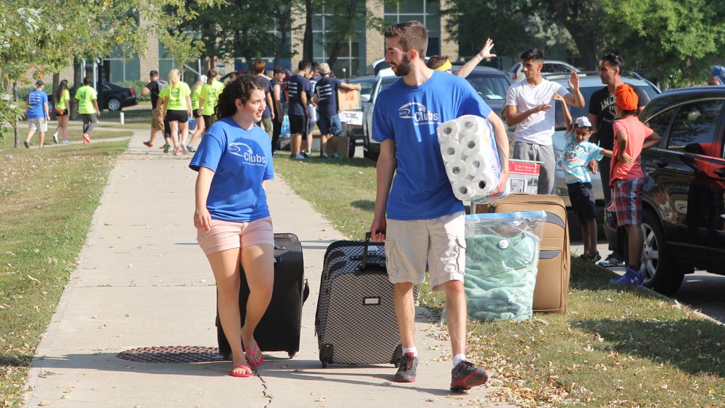 Two of the more than 850 volunteers help move a student's belongings into the Lowenberger Residence.