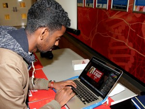 Mohamed Hassan edits a social media photo he is sending to every student who signs up to attend the #WeAreReady hype night Oct. 6.