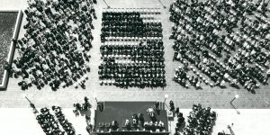 1970 Spring Convocation - X An aerial view of a large audience watches a university graduation ceremony on a rooftop next to Schmon Tower at Brock University in the 1960s inthis black and white photo.