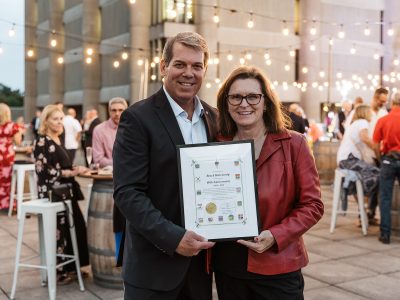 A man and a woman pose for a photo holding a framed certificate.