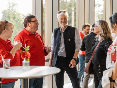A group of people smiles in conversation at a party.