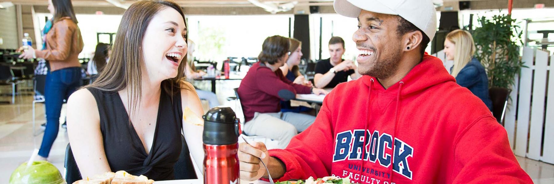 Two students talking and laughing in the dining hall