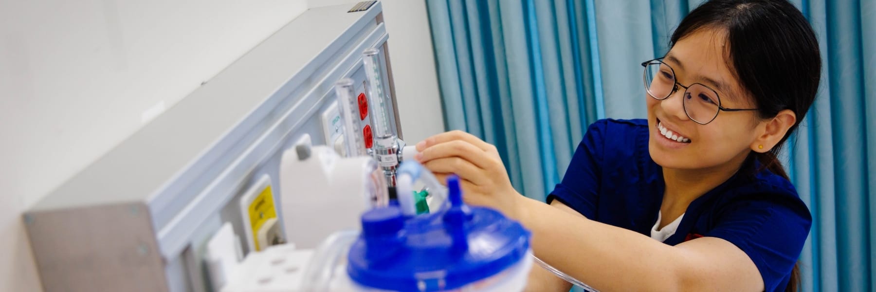 Nursing student adjusting medical equipmenrt