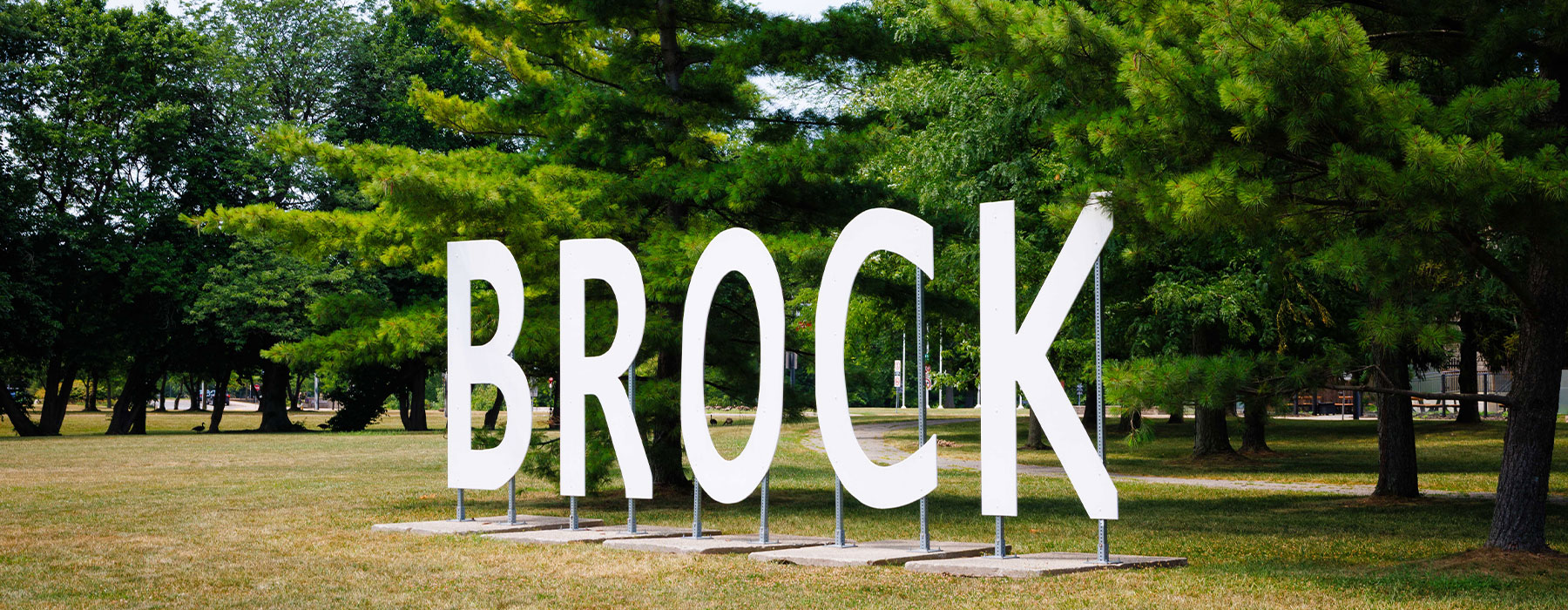 The BROCK life-size letters with trees in the background.