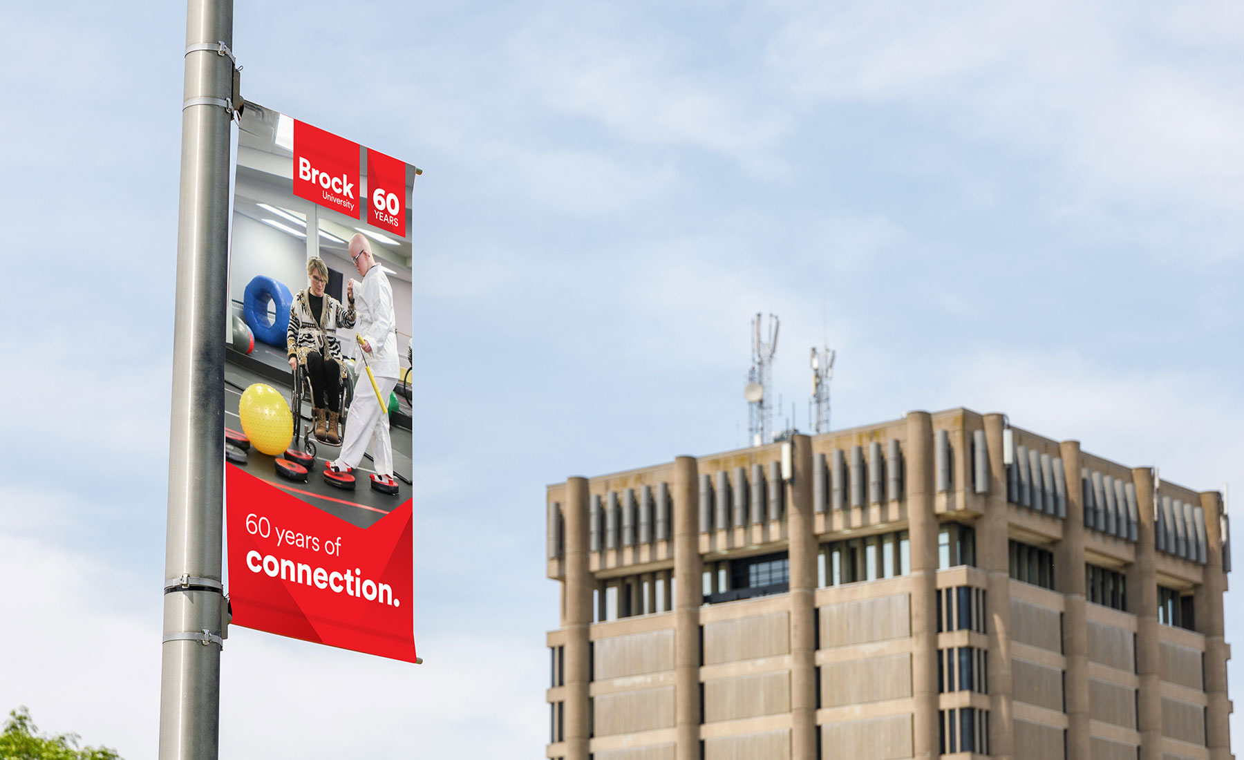 A photo of an light pole banner with the Brock tower in the background.