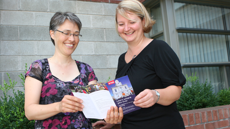 Mary-Beth Raddon and Kristen Smith with Foundations in Service Learning brochure
