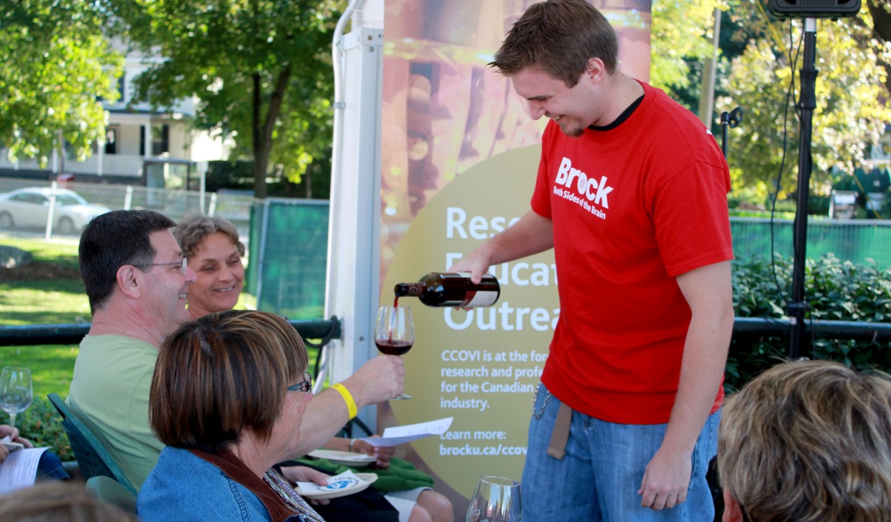 A Brock University volunteer pours wine during the Niagara Wine Festival in this file photo.