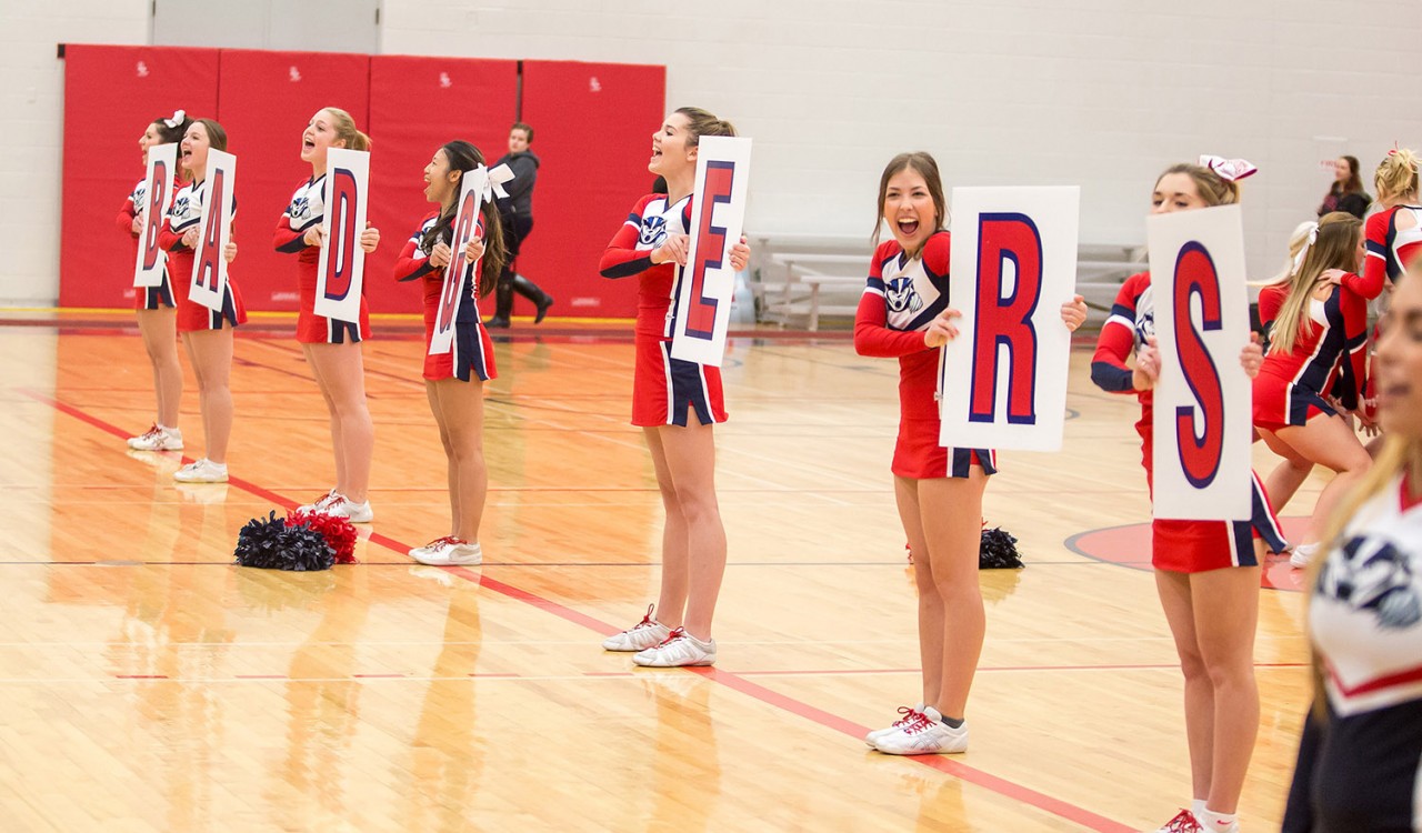 Brock cheerleaders hold up a Badgers sign in the gym.