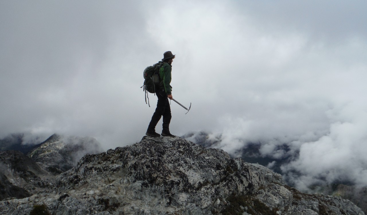 Man standing on a mountain with clouds