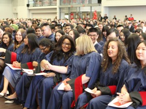 Aysha Othman shakes hands with fellow Goodman School of Business grads at the request of Chancellor Shirley Cheechoo, during her speech.