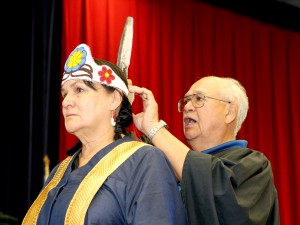 Chancellor Shirley Cheechoo is given a beaded crown with an eagle's feather by her older brother Ben Saturday during her installation ceremony.