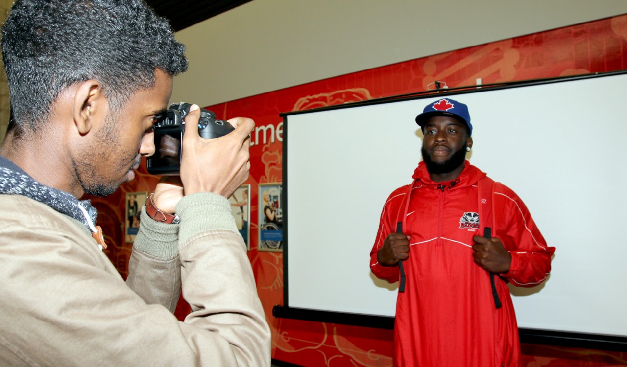 Mohamed Hassan takes a picture of Rugby player Kyle Boham for a photo he can share on social media to promote #WeAreReady hype night Oct. 6.