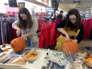 Elena Recio, left, and Liat Margulis carve pumpkins in the Campus Store Friday, Oct. 30.