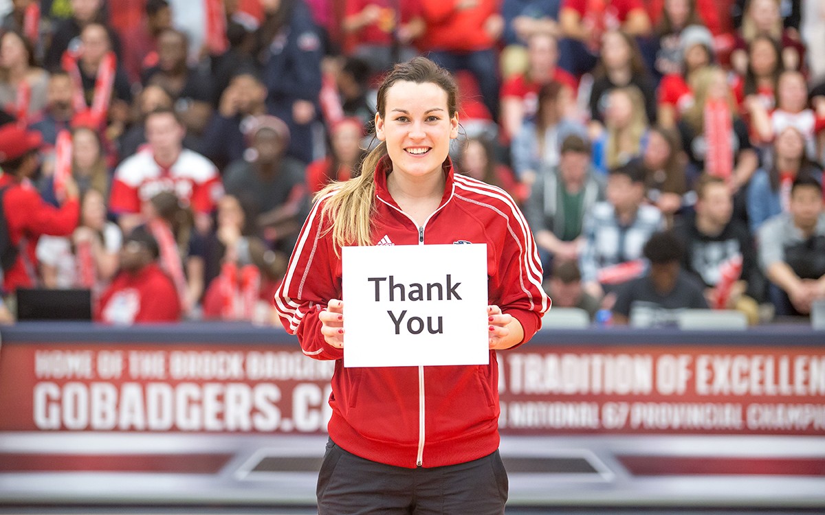 An athlete holding a thank you sign