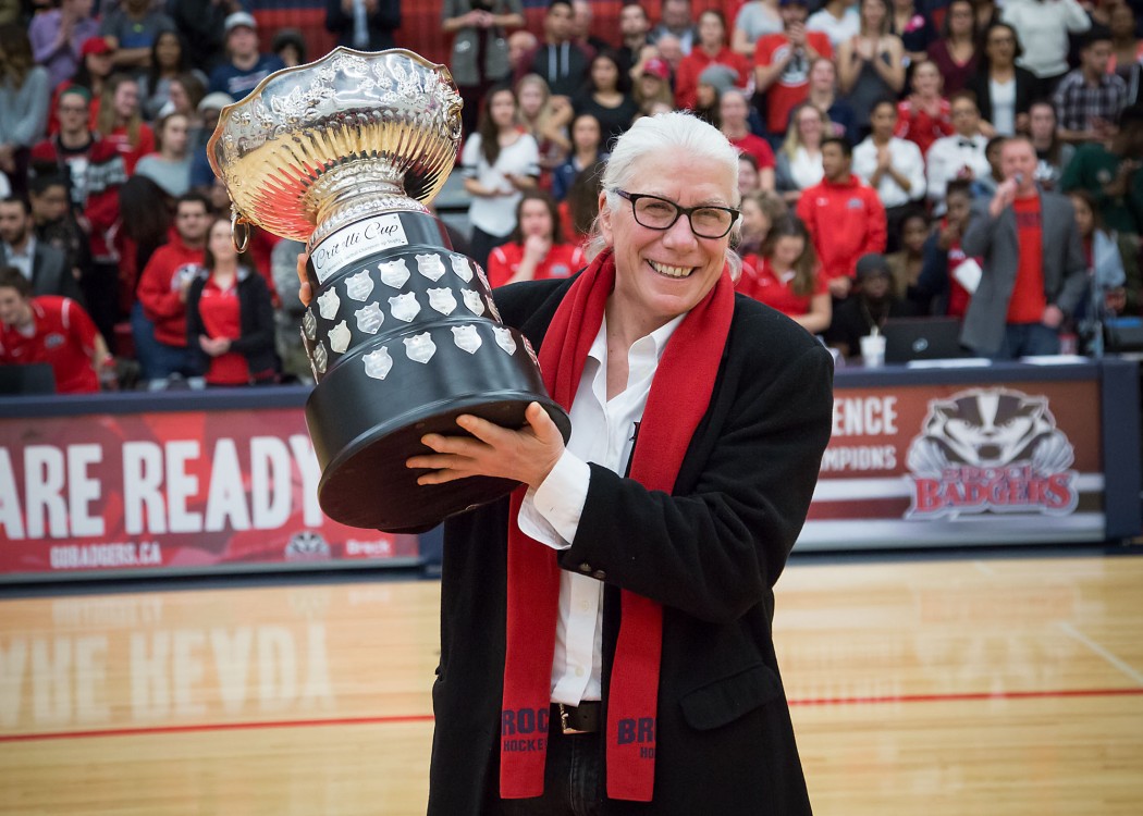 Brock University's Assistant Athletic Director Chris Critelli holds up the OUA trophy that's been renamed the Critelli Cup in her honour.