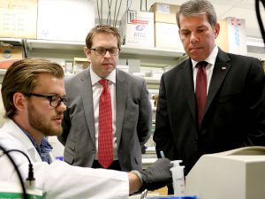 Brock University student Aindriu Maguire, an NSERC Undergraduate Student Research Awardee, explains cell research to Members of Parliament Vance Badawey (Niagara Centre), right, and Chris Bittle (St. Catharines) in the lab of Assistant Professor of Health Sciences Adam MacNeil during a tour at Brock University Tuesday, June 28.
