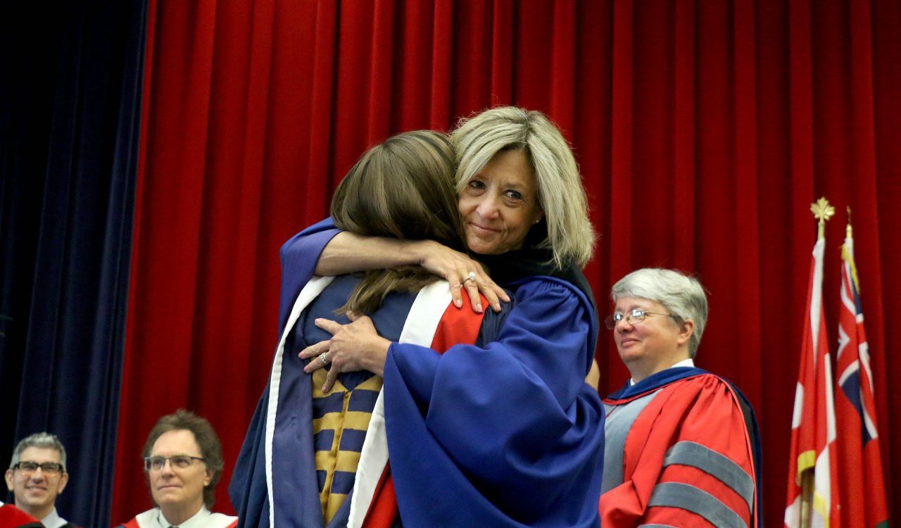 Retiring Registrar Barb Davis hugs her daughter Hannah Anderson after handing her an honours bachelor of arts degree during convocation Wednesday.