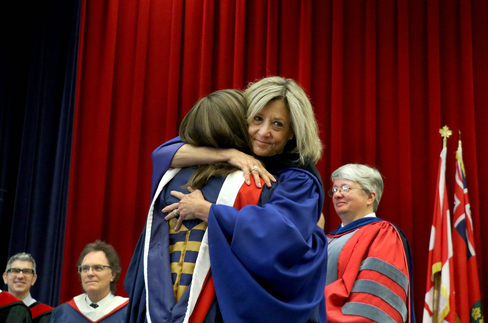 Retiring Registrar Barb Davis hugs her daughter Hannah Anderson after handing her an honours bachelor of arts degree during convocation Wednesday.
