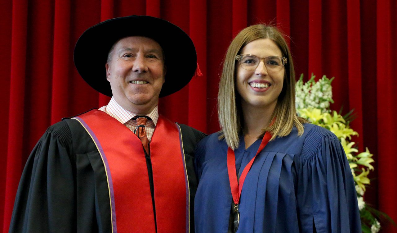 Goodman School of Business graduate student Regan Fitzgerald received the Board of Trustees Spirit of Brock award from Dennis Hewko Thursday at morning convocation.